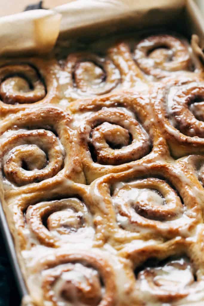 cinnamon rolls in a baking pan with glossy icing on top