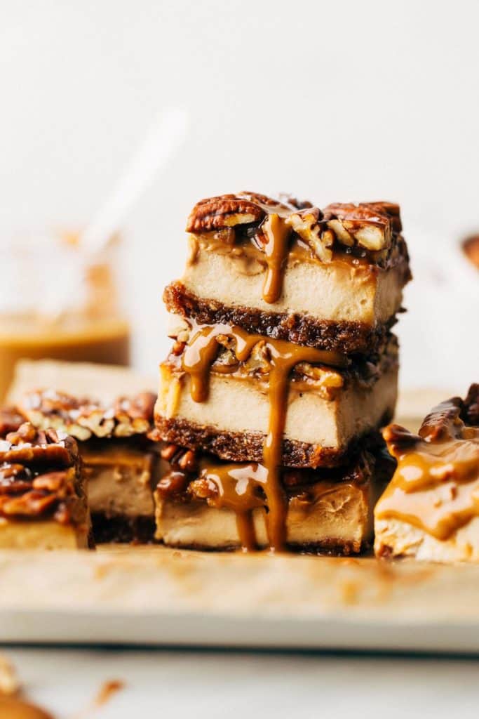 a stack of three slices of caramel pecan cheesecake bars